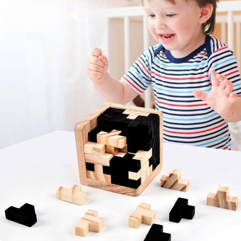 Bébé en marinière qui applaudit de joie devant le puzzle cube 3D bois naturel noir assemblé - casse-tête enfant 6-10 ans - Atelier Puzzle