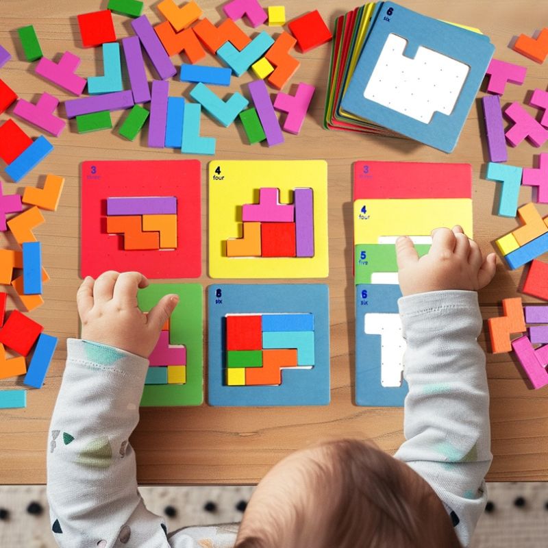 Bébé vue dessus deux mains sur 6 plateaux colorés puzzle Tetris bois pièces éparpillées - jeu logique éducatif enfant 3-8 ans - Atelier Puzzle
