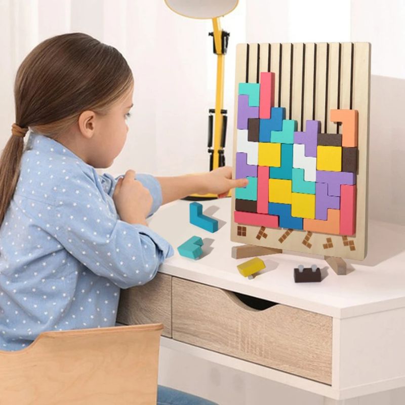 Fille concentrée pointe puzzle Tetris bois chevalet blocs colorés pastel - jeu logique formes géométriques enfant 4-6 ans - Atelier Puzzle