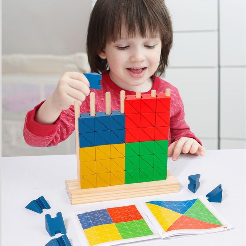 Garçon pull rouge souriant qui place bloc bleu sur structure blocs arc-en-ciel tiges verticales - jeu créatif construction enfant 4-8 ans - Atelier Puzzle