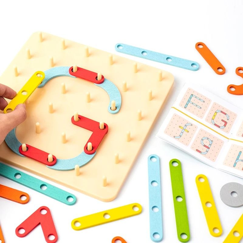 Gros plan géoboard bois lettre G pièces colorées éparpillées - jeu construction lettres enfant Montessori - Atelier Puzzle