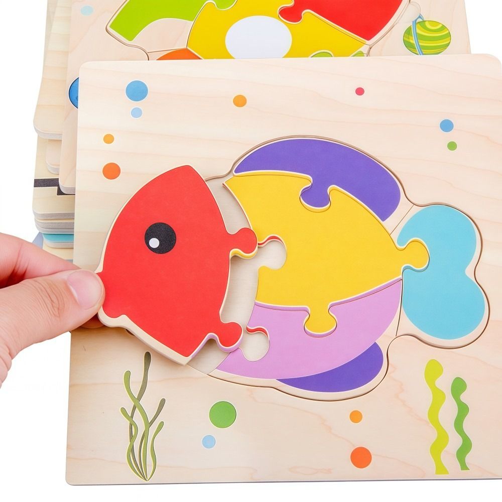 Gros plan main assemble puzzle  poisson multicolore encastrement - qualité bois enfant - Atelier Puzzle