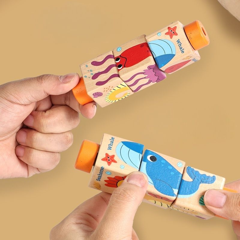 Gros plan mains adulte qui font glisser blocs puzzle cylindre rotatif bois animaux marins baleine hippocampe - motricité fine jeu Montessori enfant 2-4 ans - Atelier Puzzle