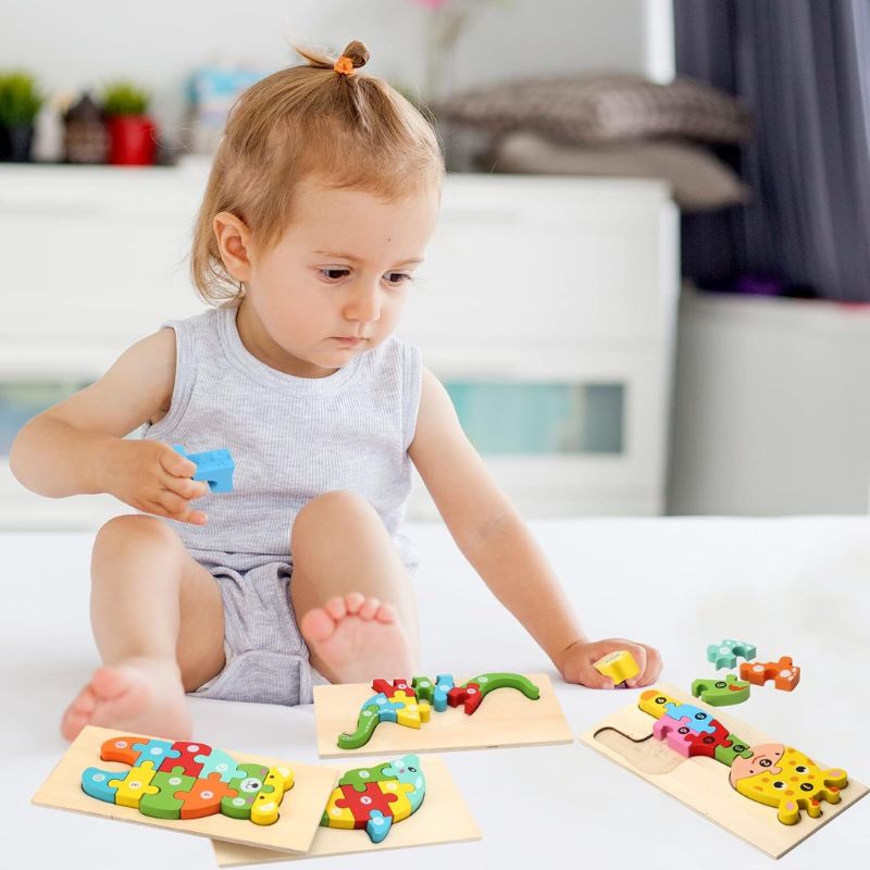 Petite fille assise au sol joue avec plusieurs puzzles 3D bois chiffres animaux - jeu voyage maison sans écran enfant - Atelier Puzzle
