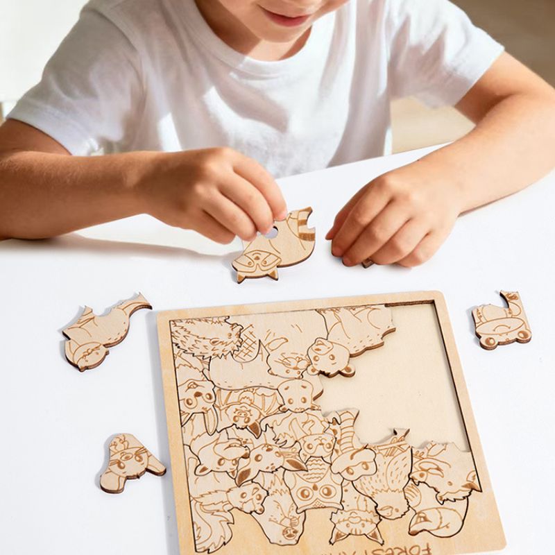 Garçon concentré qui assemble puzzle bois gravé pièces irrégulières animaux gros plan mains - jeu logique spatial enfant 5-10 ans - Atelier Puzzle