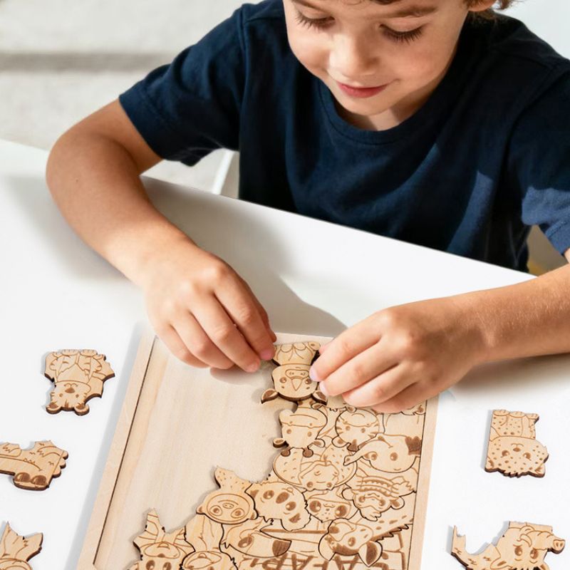 Garçon tient pièce puzzle bois gravé forêt à deux mains concentration précision - jeu logique spatial enfant - Atelier Puzzle