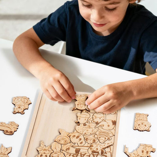 Garçon tient pièce puzzle bois gravé forêt à deux mains concentration précision - jeu logique spatial enfant - Atelier Puzzle