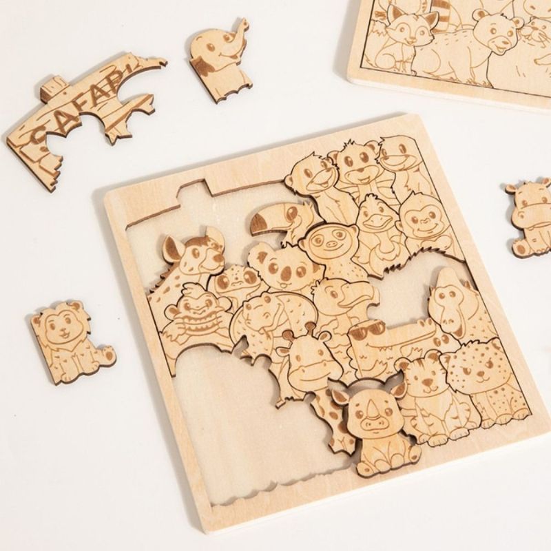 Plateau puzzle bois gravé safari en cours assemblage pièces irrégulières animaux éparpillées - qualité découpe laser - Atelier Puzzle