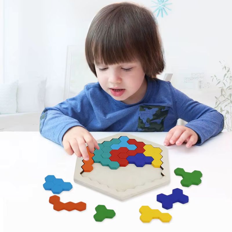 Enfant concentré qui joue seul au puzzle hexagonal tangram en bois - jeu logique autonomie enfant 4-8 ans - Atelier Puzzle
